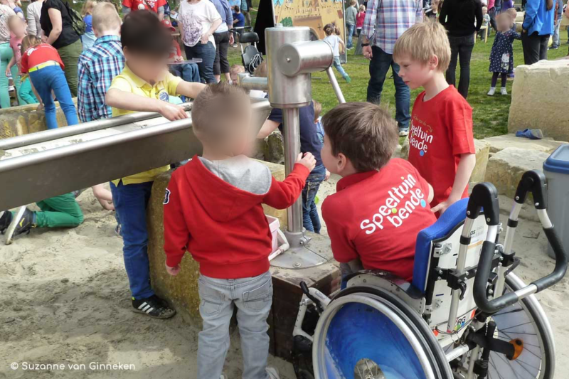 Kinderen met en zonder handicap spelen bij de waterpomp en watergoot