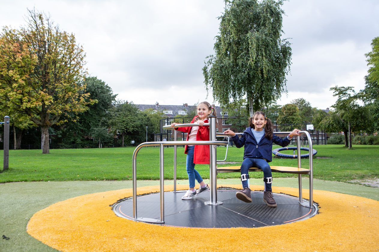 Saharsha en een vriendinnetje spelen samen in een draaimolen